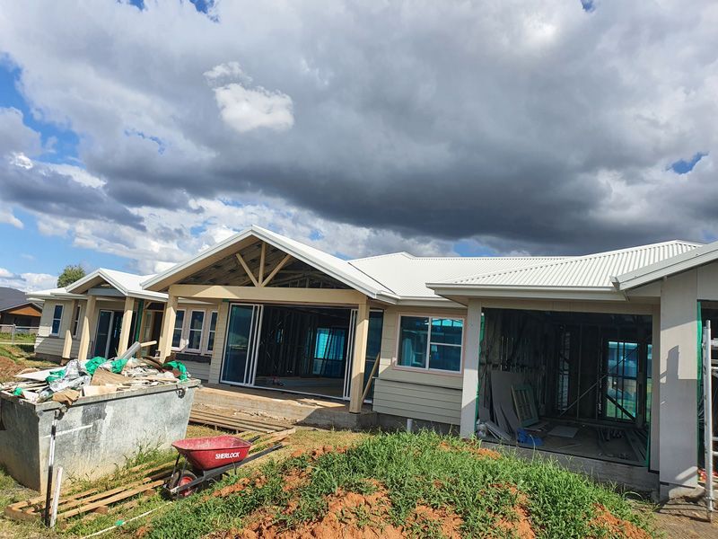 A House is Being Built on a Hill With a Wheelbarrow in Front of It — Kareela Constructions In Narrabri, NSW