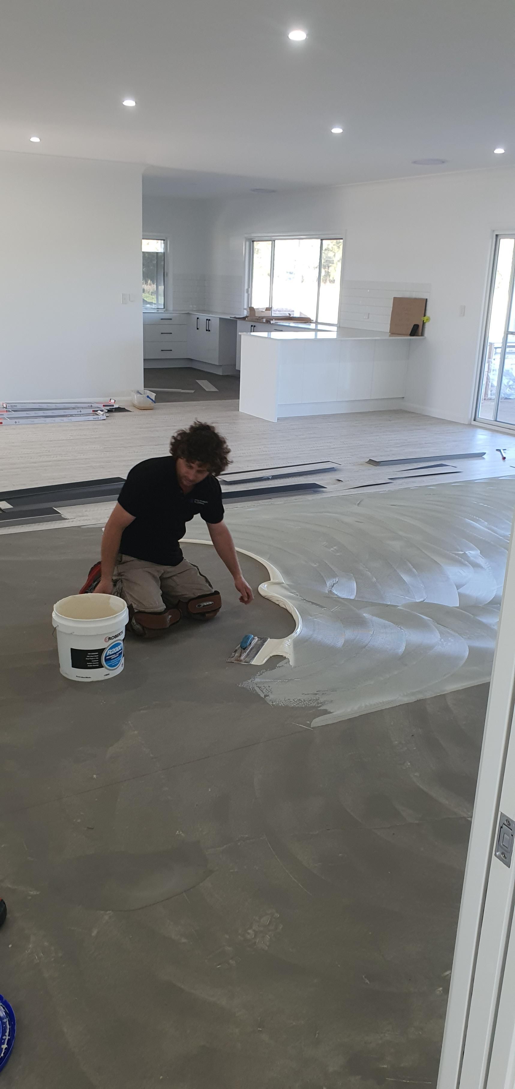 A Man is Kneeling on the Floor in a Room — Kareela Constructions In Tamworth, NSW