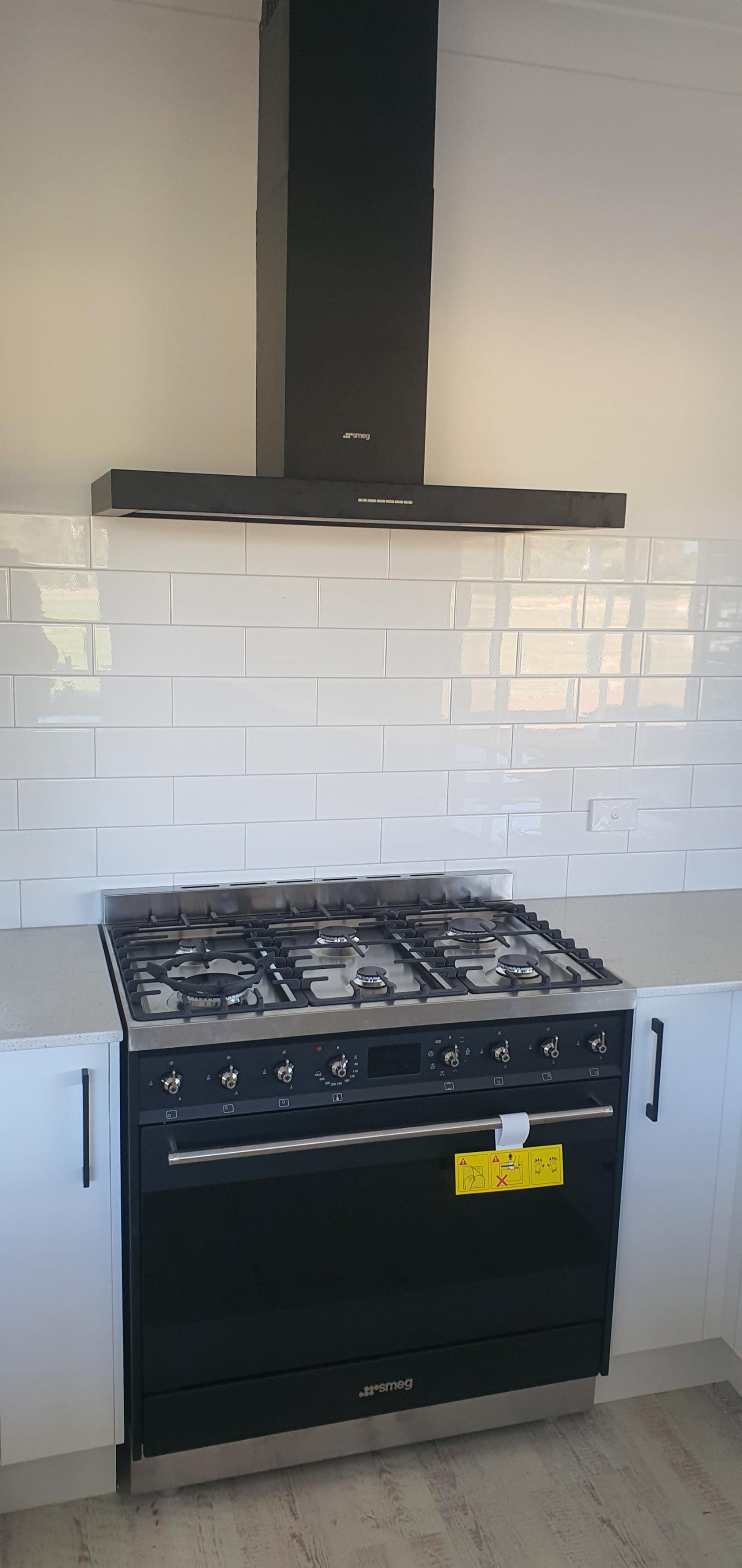 A Black Stove Top Oven is Sitting in a Kitchen — Kareela Constructions In Tamworth, NSW