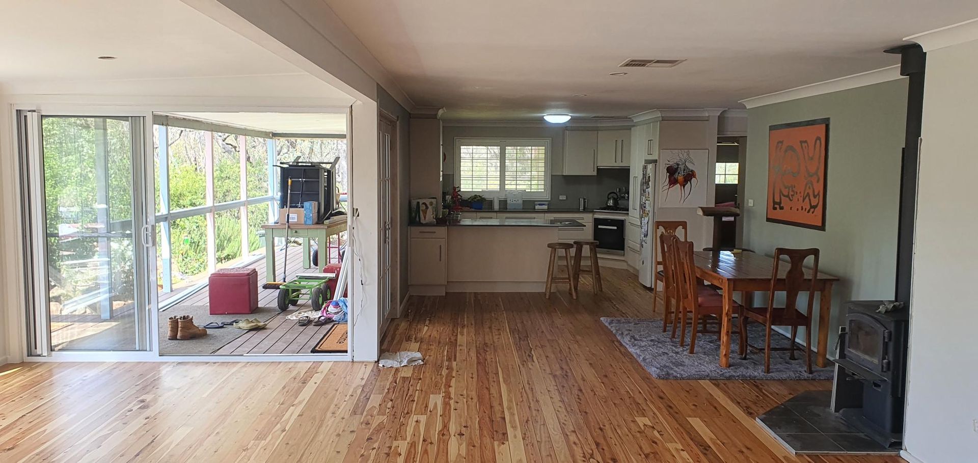 A Living Room With Hardwood Floors, a Table and Chairs, and a Kitchen — Kareela Constructions In Tamworth, NSW