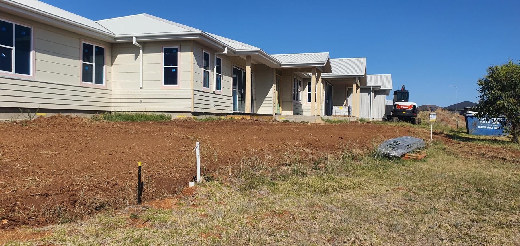 A Large White House is Sitting on Top of a Dirt Field — Kareela Constructions In Tamworth, NSW