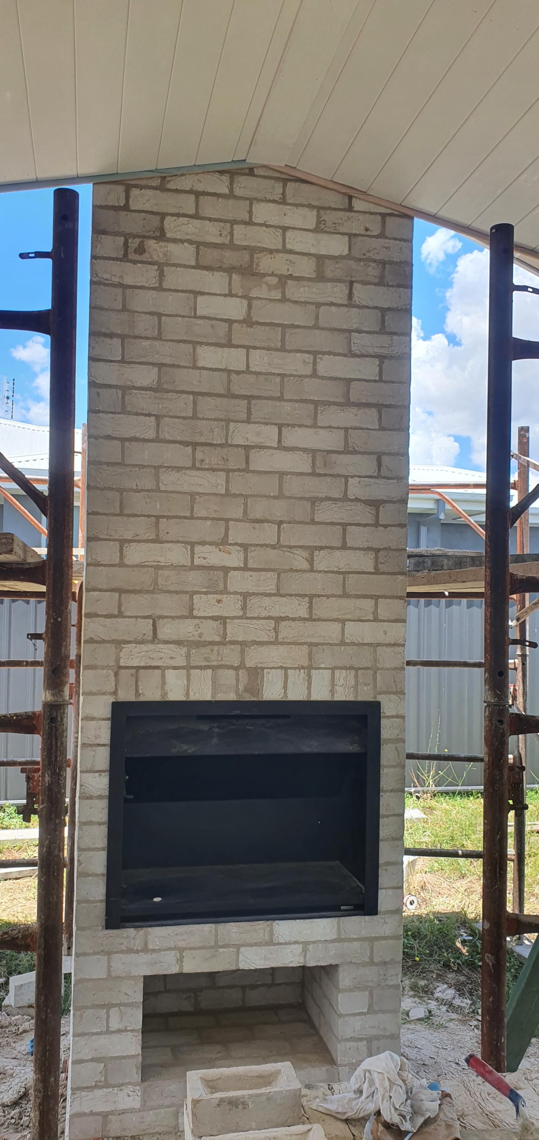 A Brick Fireplace is Being Built in the Backyard of a House — Kareela Constructions In Tamworth, NSW