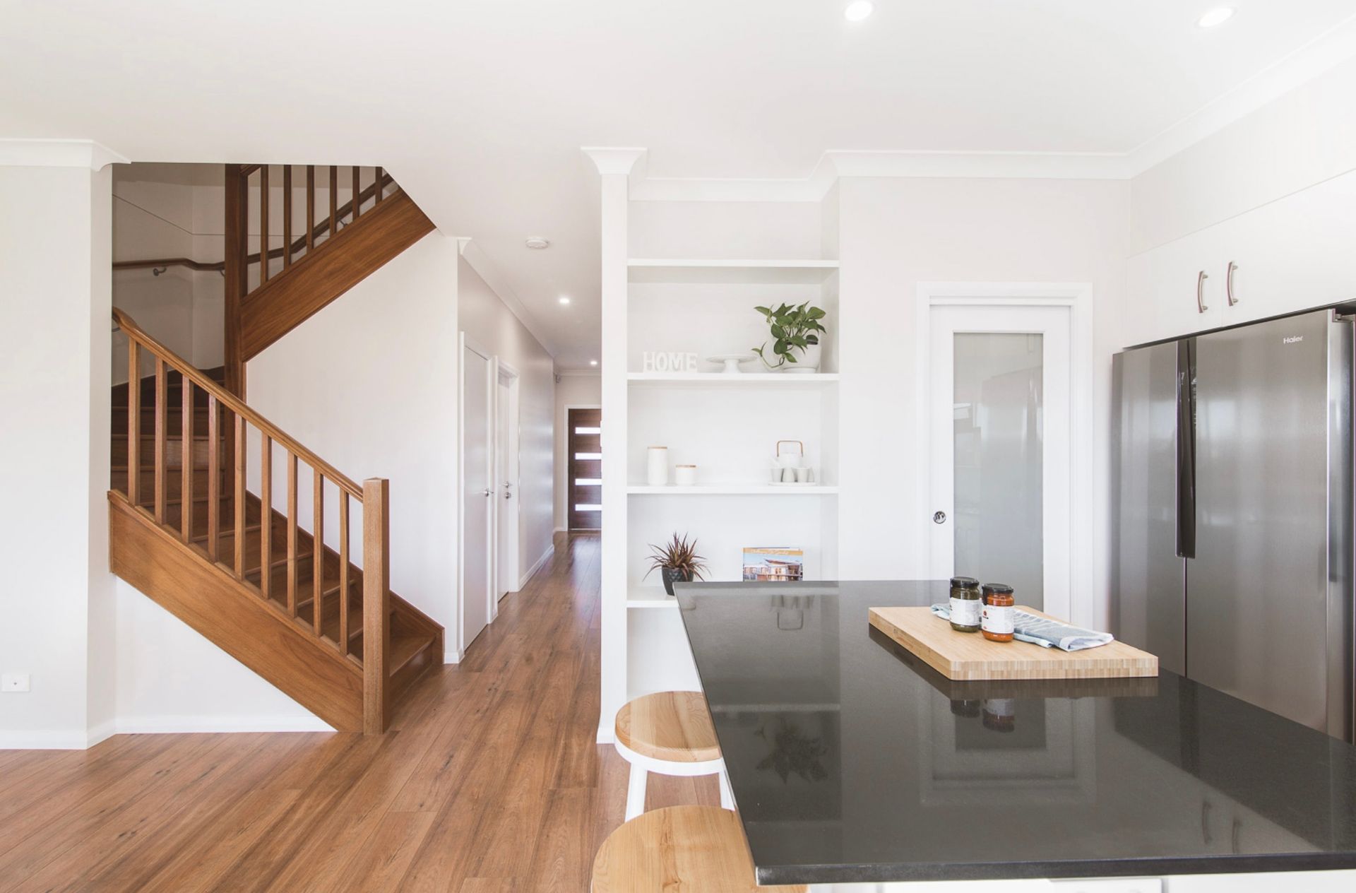 A Kitchen With a Black Counter Top and a Wooden Staircase — Kareela Constructions In Tamworth, NSW