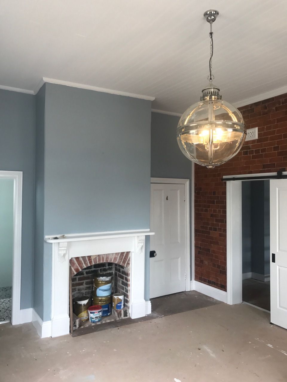 A Living Room With a Fireplace and a Chandelier Hanging From the Ceiling — Kareela Constructions In Tamworth, NSW