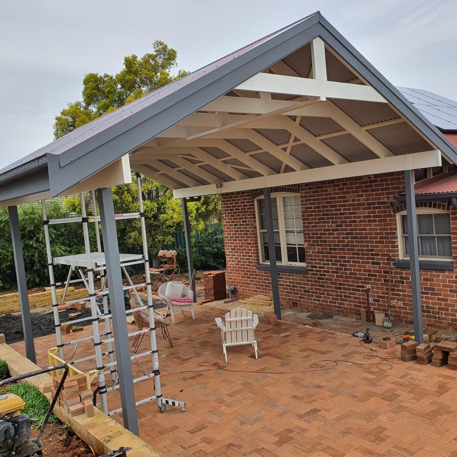 A Brick House With a Covered Porch and a Ladder in Front of It — Kareela Constructions In Tamworth, NSW