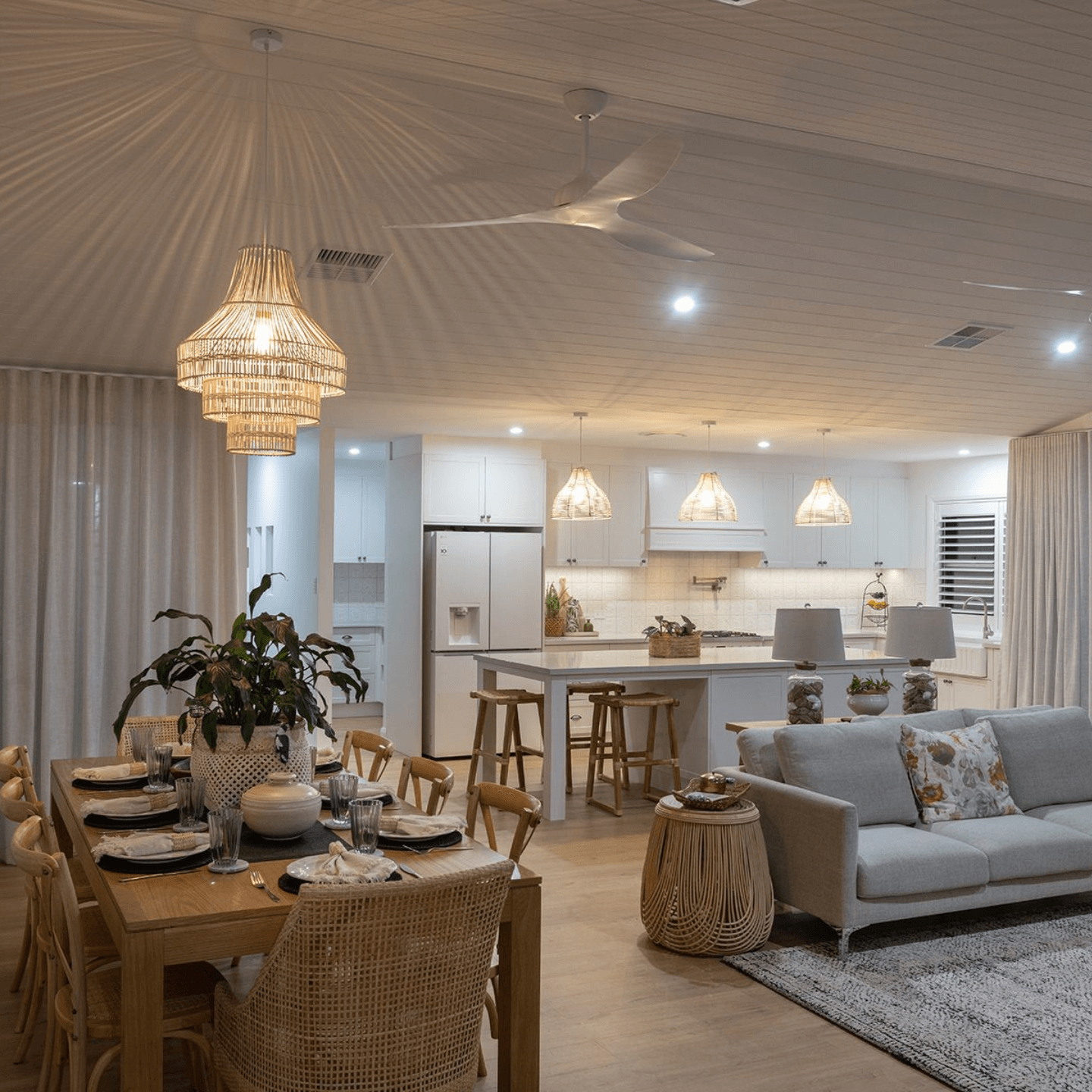 A Dining Room With a wooden table and chandelier lights