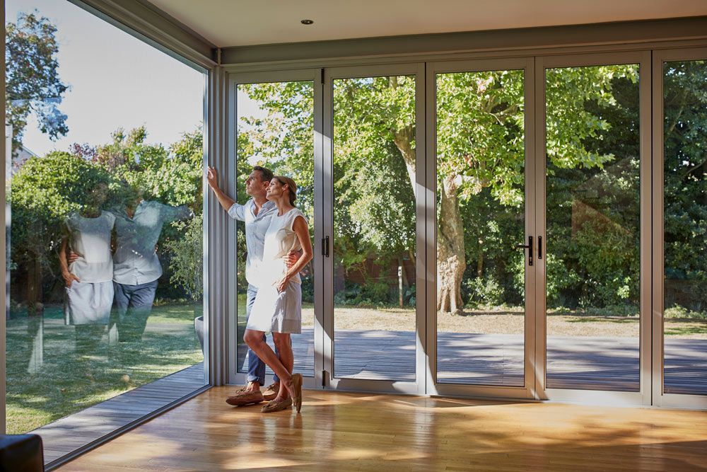 Couple Looking Through Glass Walls of A House Extension