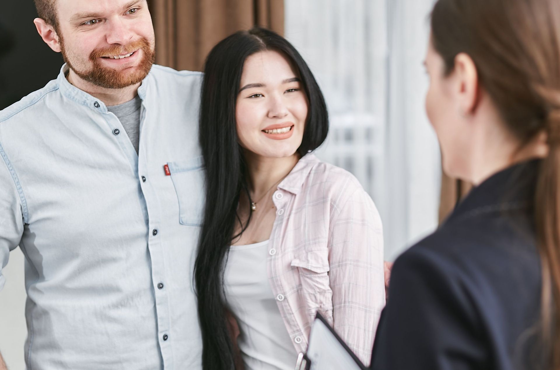 Three people smiling in a bright office conversation