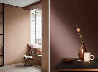 Minimalistisk beige rom med vindusbenk og et mørkt bord med en vase, et krus og en skål.