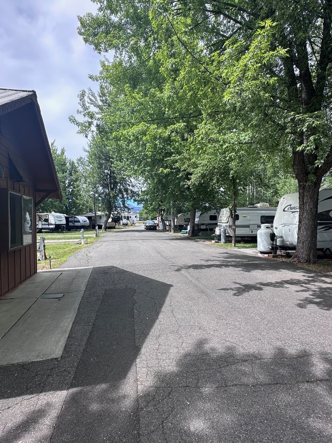 A row of rvs parked on the side of a road next to a building.