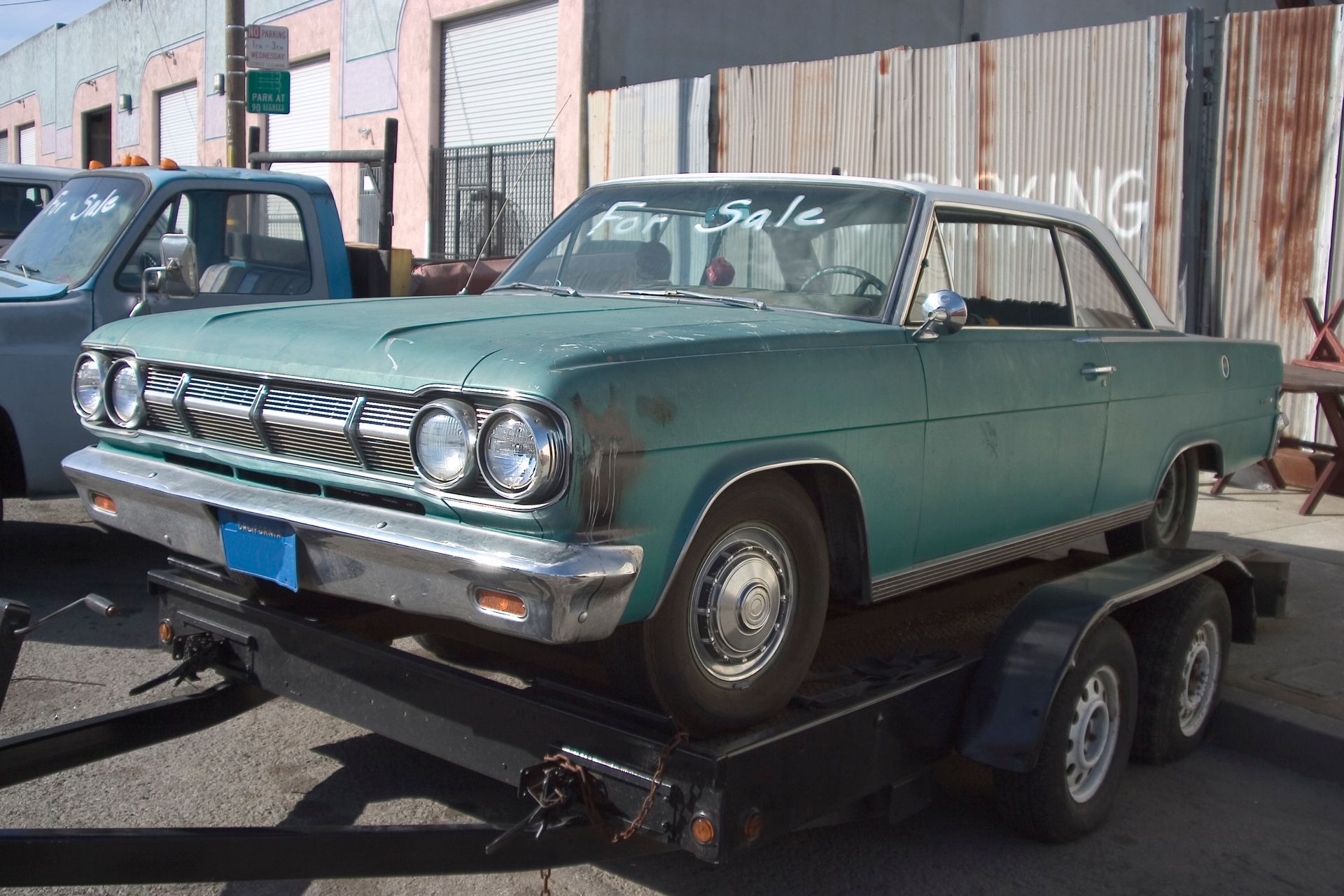 Green classic car on trailer,