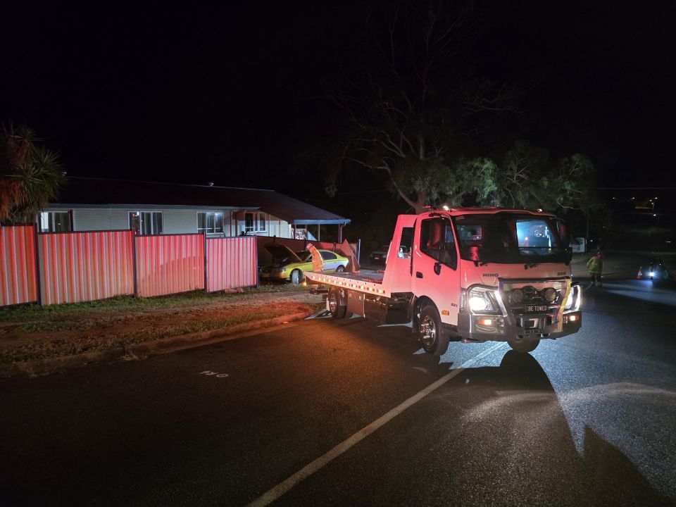 A Tow Truck is Towing a Car in Front of a House at Night — Tow Biz in Park Avenue, QLD
