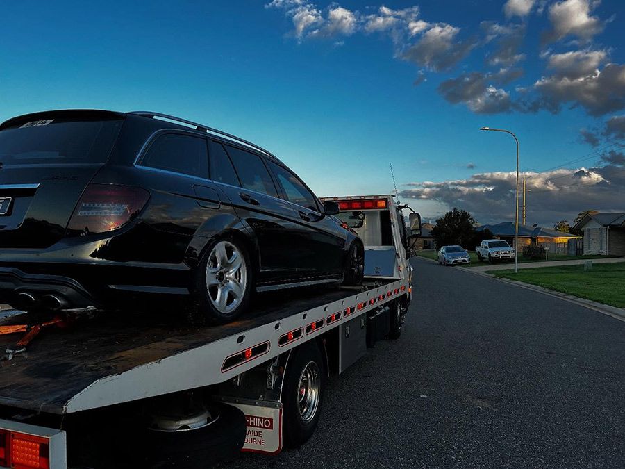 A Black Car is Sitting on Top of a Tow Truck — Tow Biz in Park Avenue, QLD