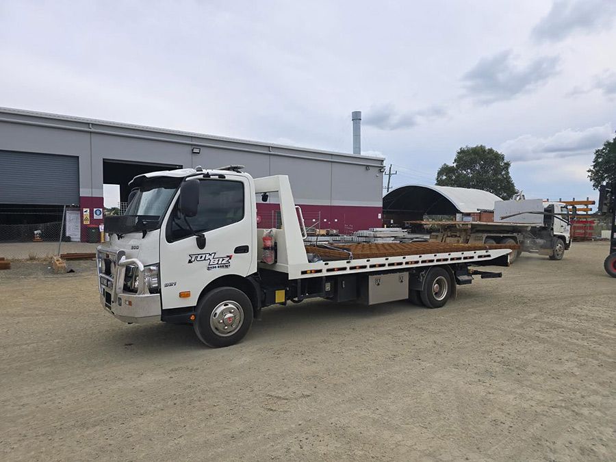 A Tow Truck is Parked in a Dirt Lot in Front of a Building — Tow Biz in Park Avenue, QLD