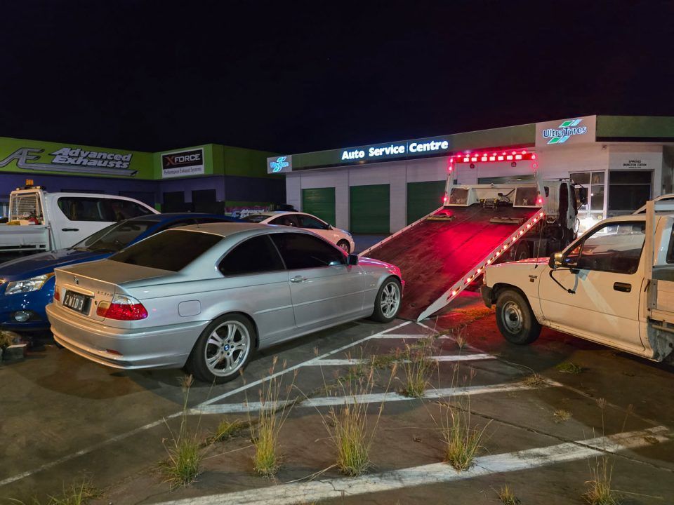 A Silver Car is Being Towed by a Tow Truck in a Parking Lot — Tow Biz in Park Avenue, QLD