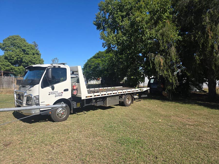 A White Tow Truck is Parked in a Grassy Field — Tow Biz in Park Avenue, QLD