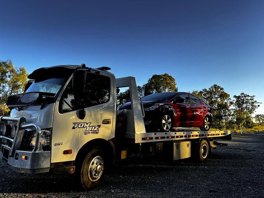 A Tow Truck With Two Cars on the Back of It — Tow Biz in Park Avenue, QLD