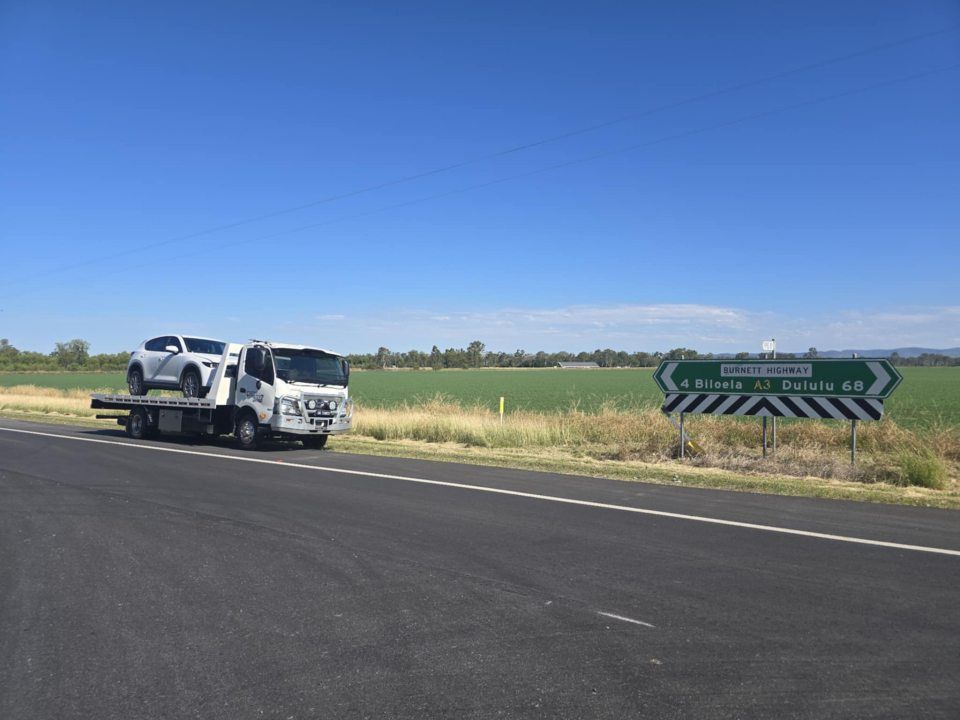 A Tow Truck is Carrying a Car on the Back of It — Tow Biz in Biloela, QLD