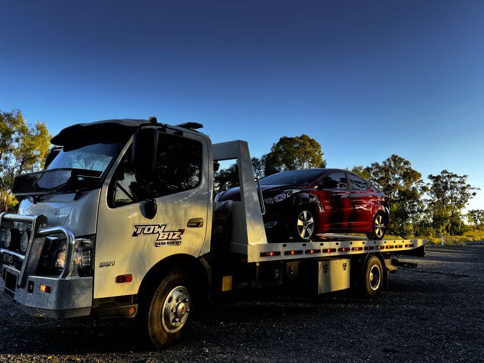 A Tow Truck With a Red Car on the Back of It — Tow Biz in Park Avenue, QLD