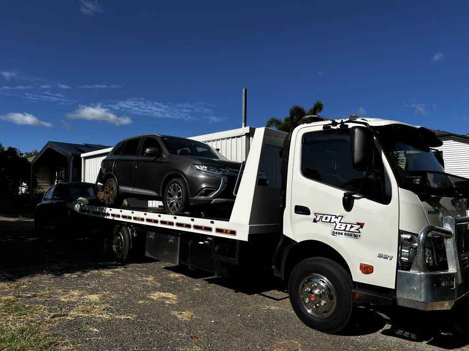 A Tow Truck is Carrying a Car on the Back of It — Tow Biz in Biloela, QLD