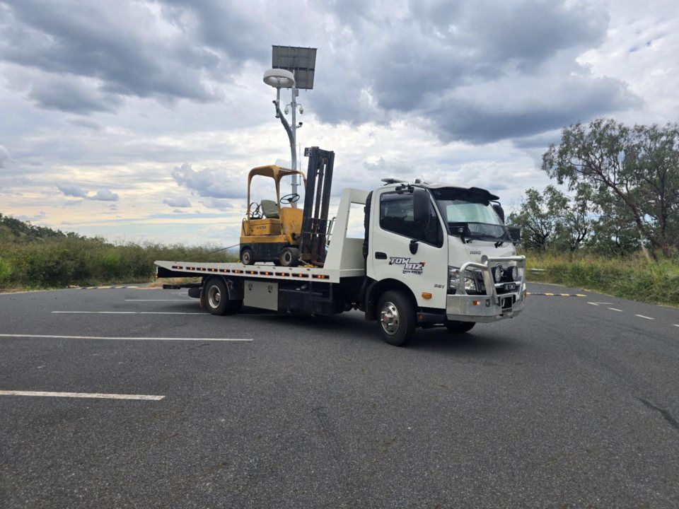 A Tow Truck With a Forklift on the Back is Parked on the Side of the Road — Tow Biz in Biloela, QLD
