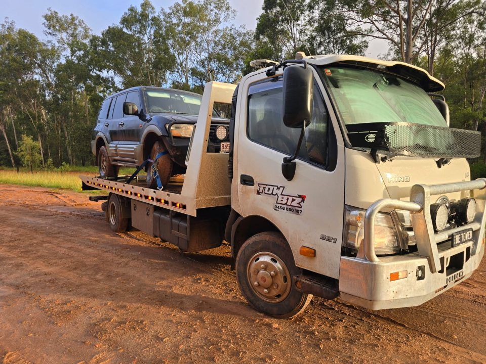 A Tow Truck is Carrying a Suv on a Dirt Road — Tow Biz in Biloela, QLD
