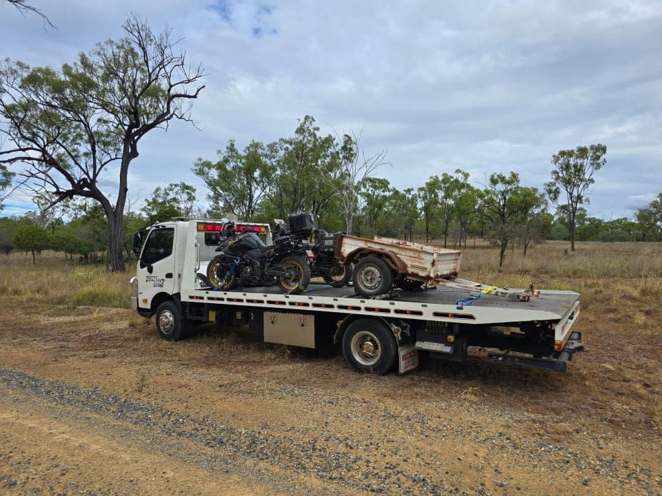 A Tow Truck is Carrying a Motorcycle and a Car on the Back of It — Tow Biz in Park Avenue, QLD