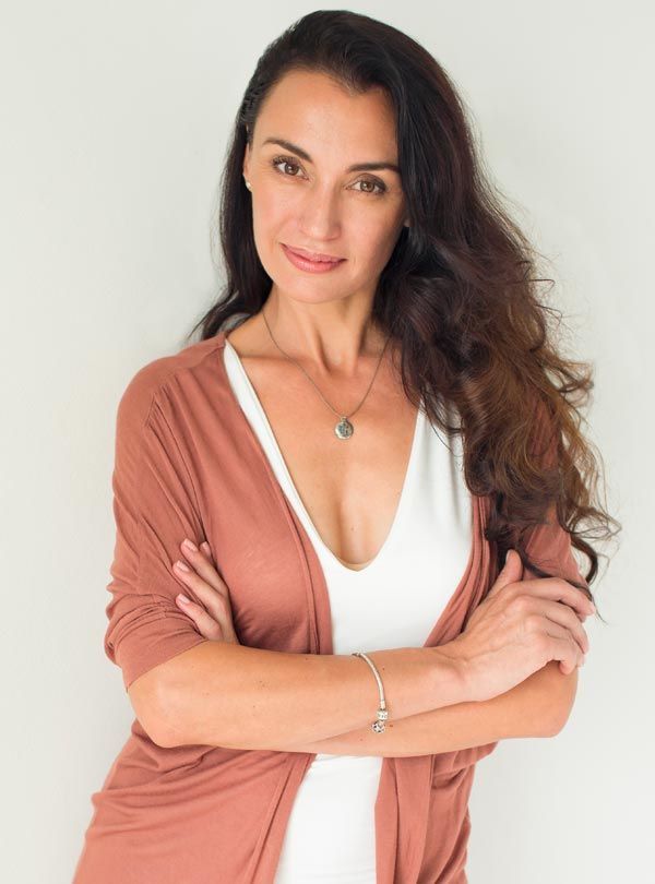 Confident mother with long dark hair smiling after a mummy makeover surgery