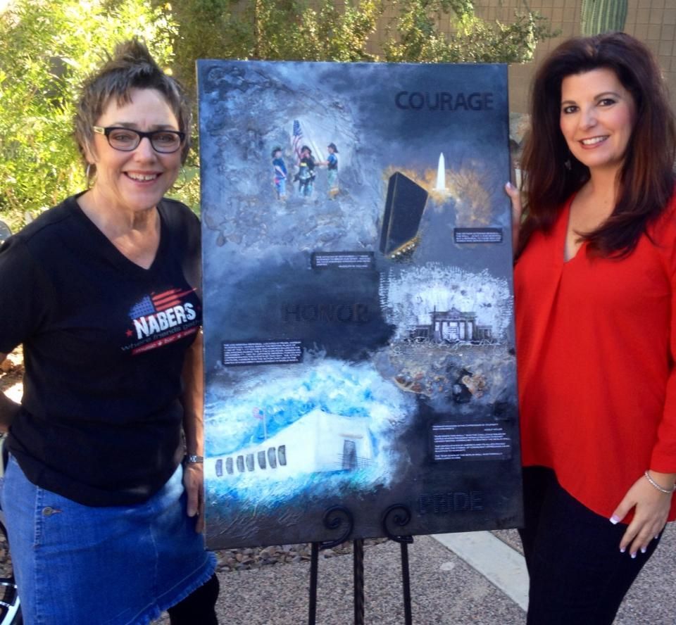Two women stand with a poster titled 