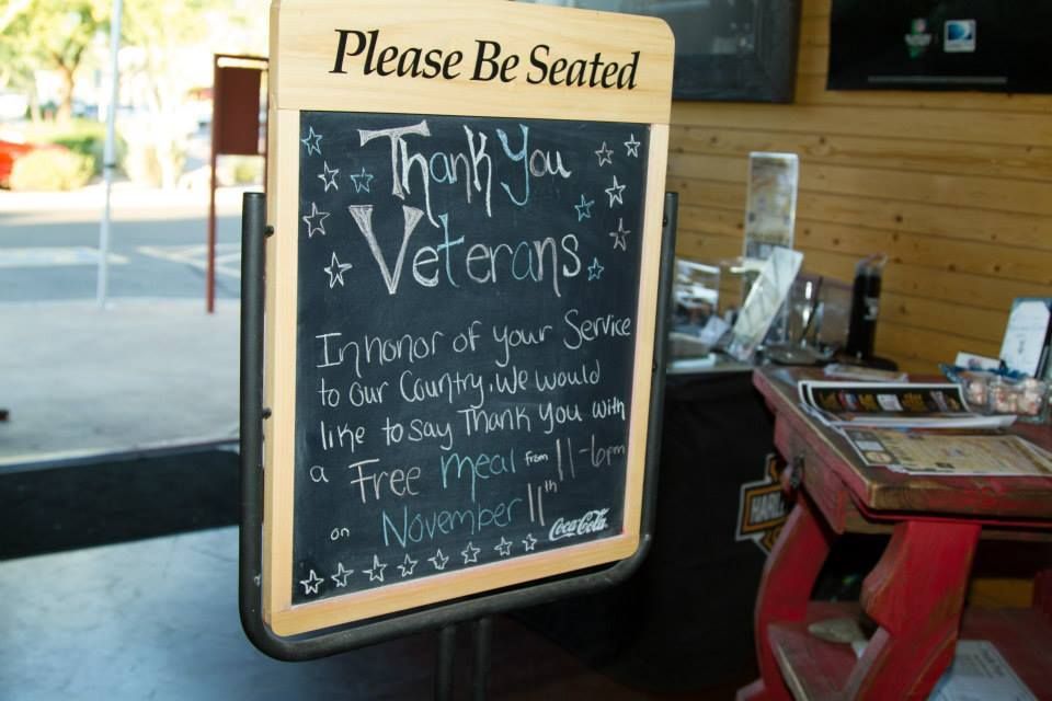 A chalkboard sign in a restaurant entry offers a free meal to veterans on November 11th.