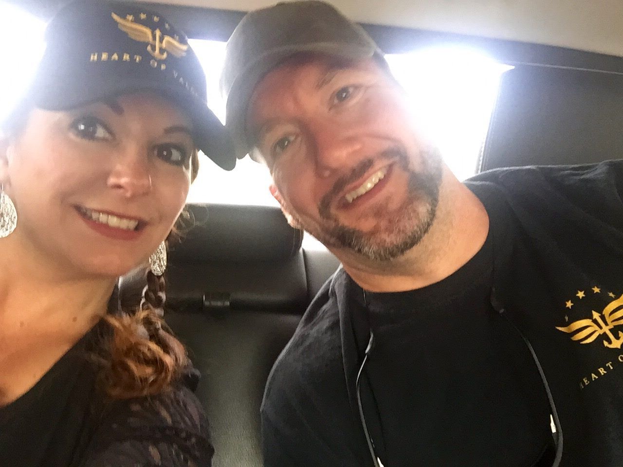 Two people smiling, wearing matching 
