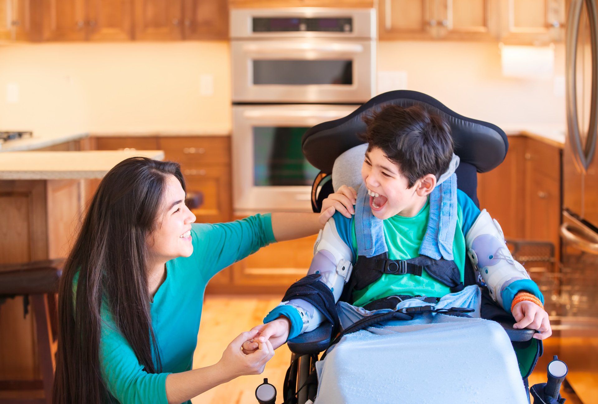Mom laughing with son in wheelchair