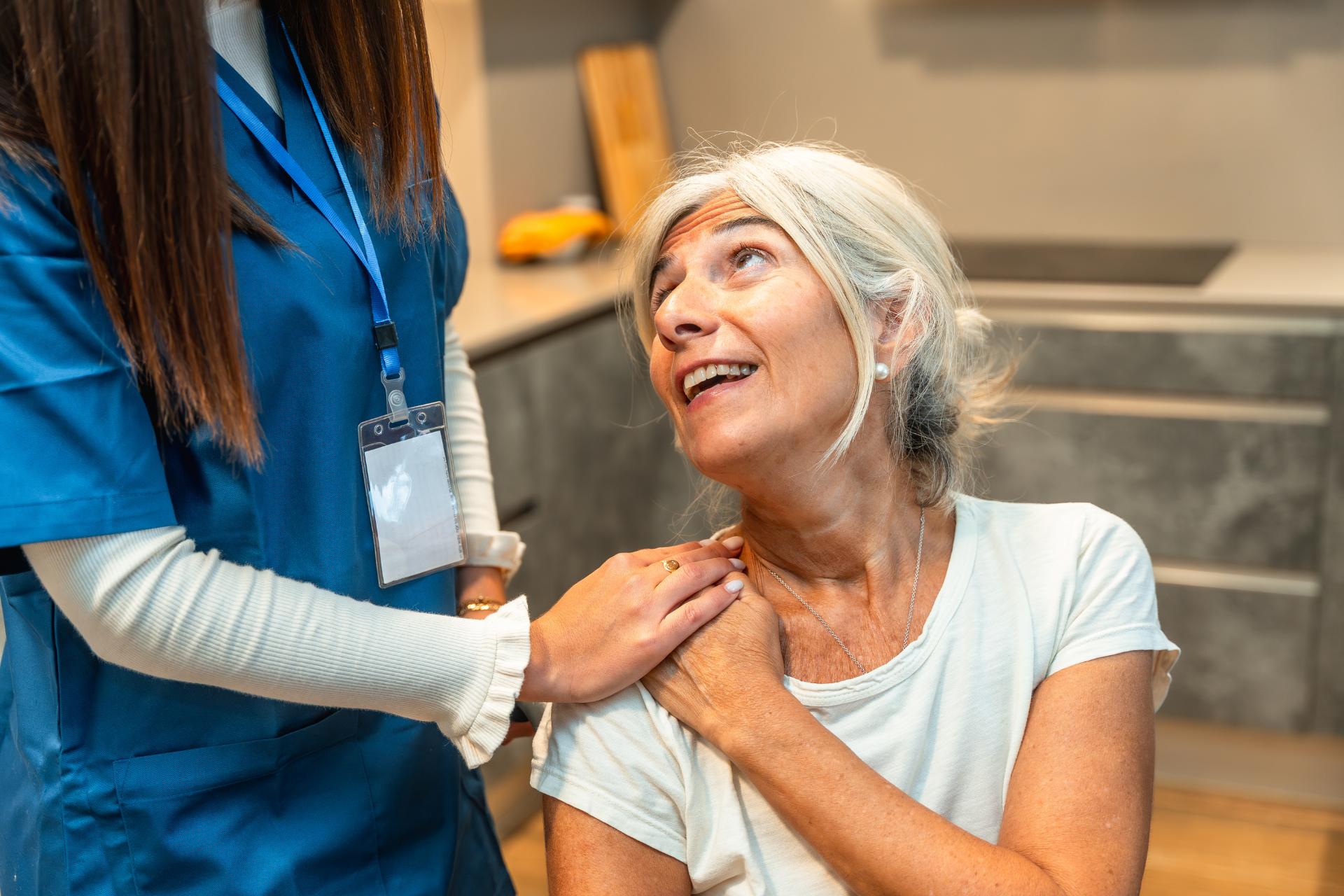 Healthcare worker comforting a smiling patient in a hospital setting