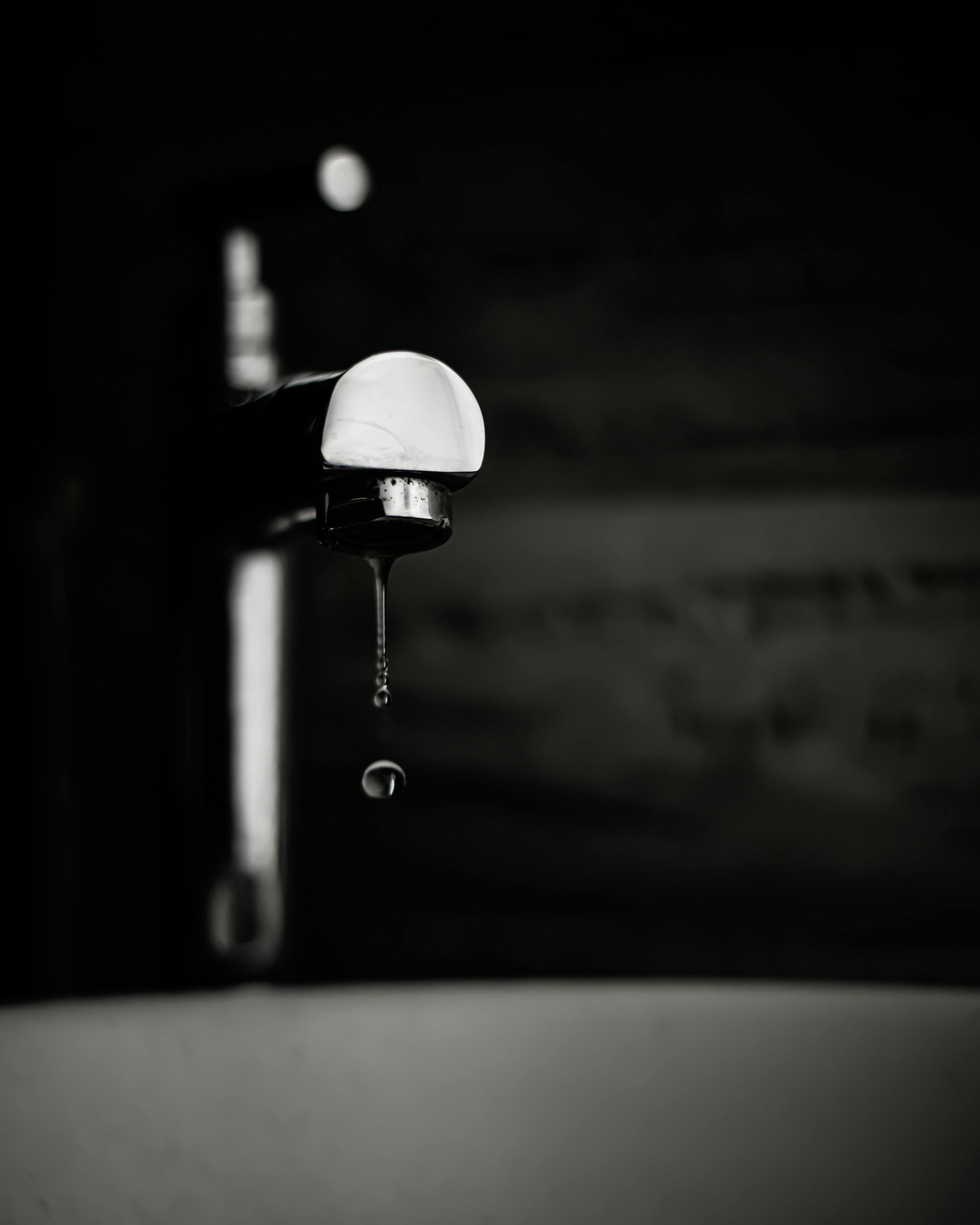 A person is pouring water into a glass on a table.