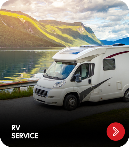 RV parked on a road by a lake and mountains; 