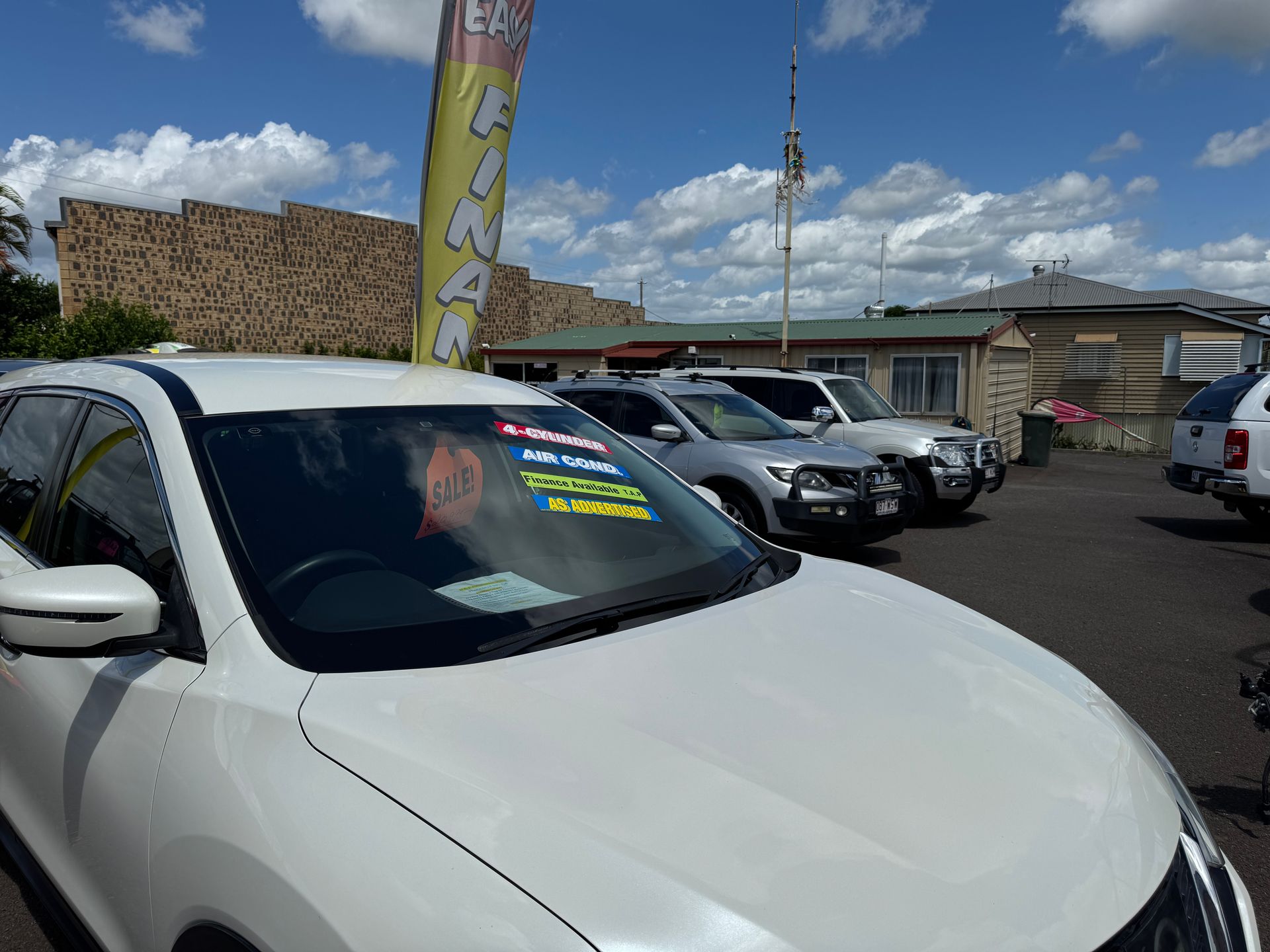 A White Car is Parked in Front of a Building — N & R Automotive Group in Bundaberg East, QLD