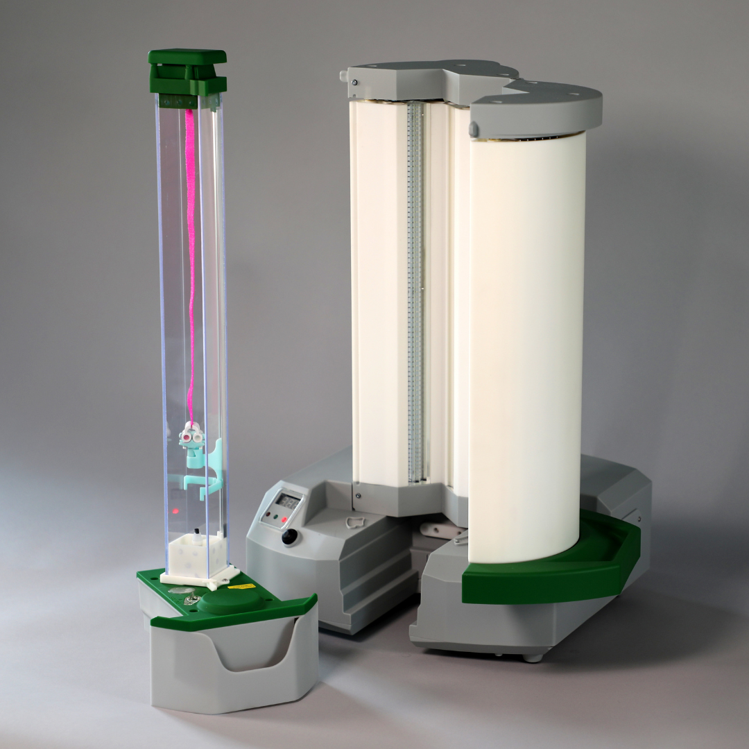 A white cylinder with a green top sits next to two other cylinders
