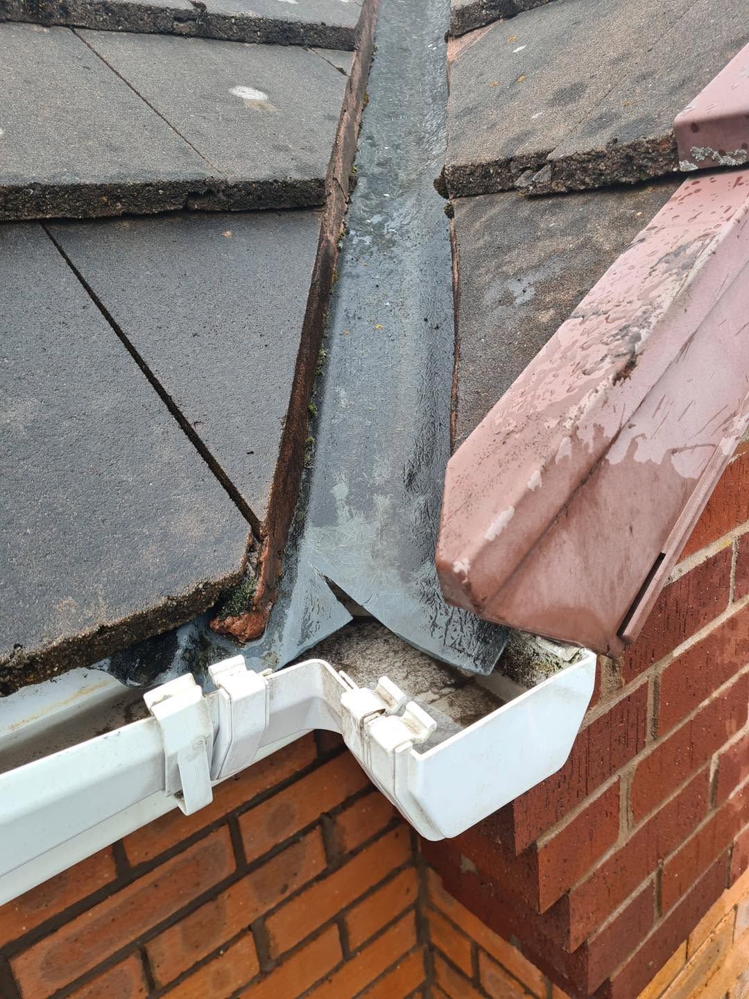 Gutter corner beneath a roof valley in Perton after vegetation and debris removal