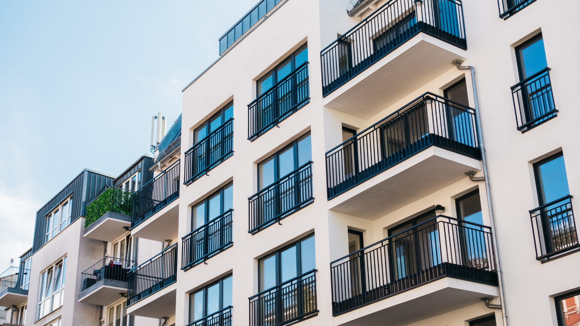 A large apartment building with lots of balconies and windows.
