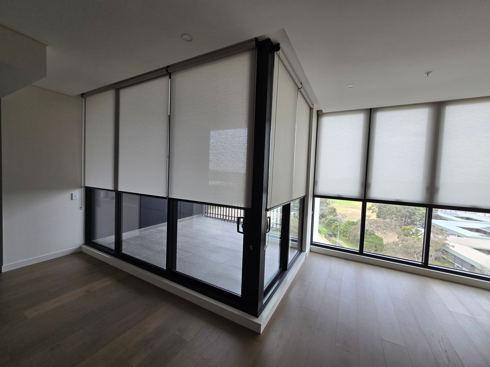 Room with floor-to-ceiling windows, sheer white blinds, and light wood flooring. — Glenn Koek - Shutters - Curtains - Blinds in Sutherland Shire, NSW