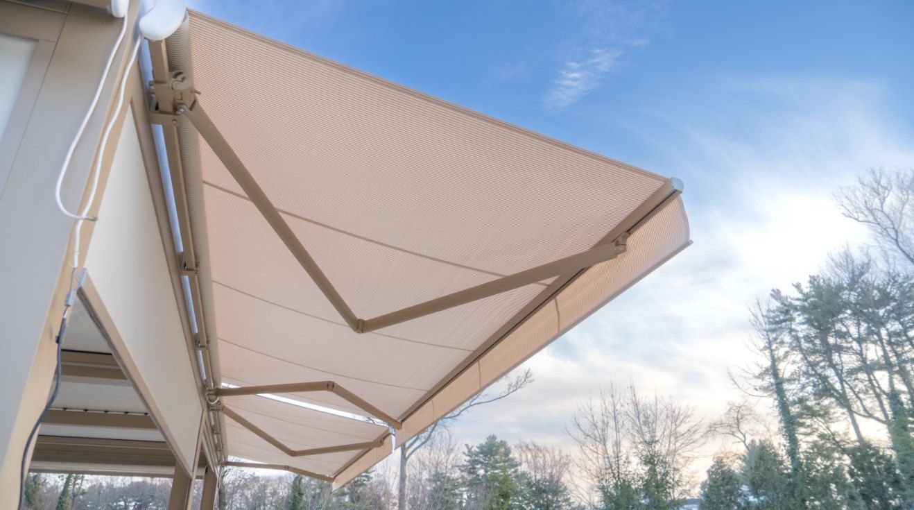 Beige Retractable Awning Extended Over a Building — Glenn Koek - Shutters - Curtains - Blinds in West Wollongong, NSW