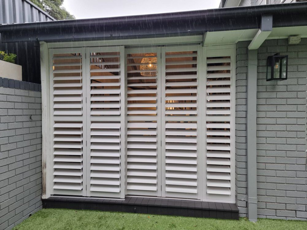 Sliding White Louvered Shutters Covering a Window — Glenn Koek - Shutters - Curtains - Blinds in Illawarra, NSW