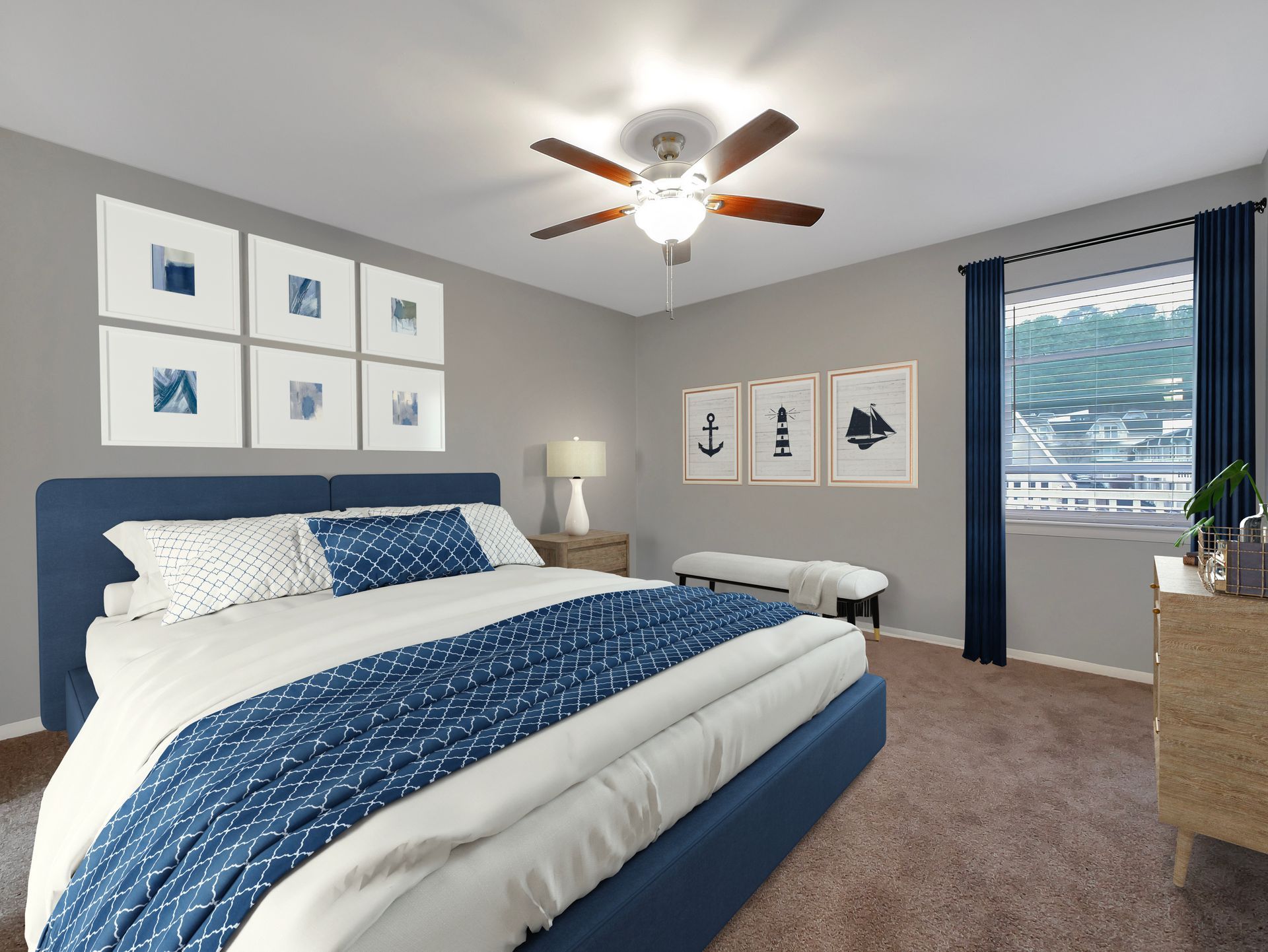 A modern bedroom with a blue upholstered bed, gray walls, nautical art, and dark blue curtains by a window.