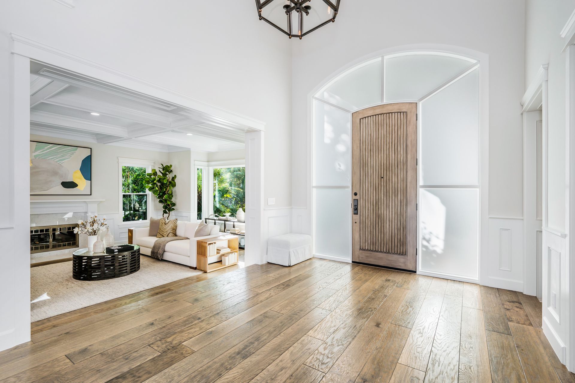 A living room with hardwood floors and a wooden door.