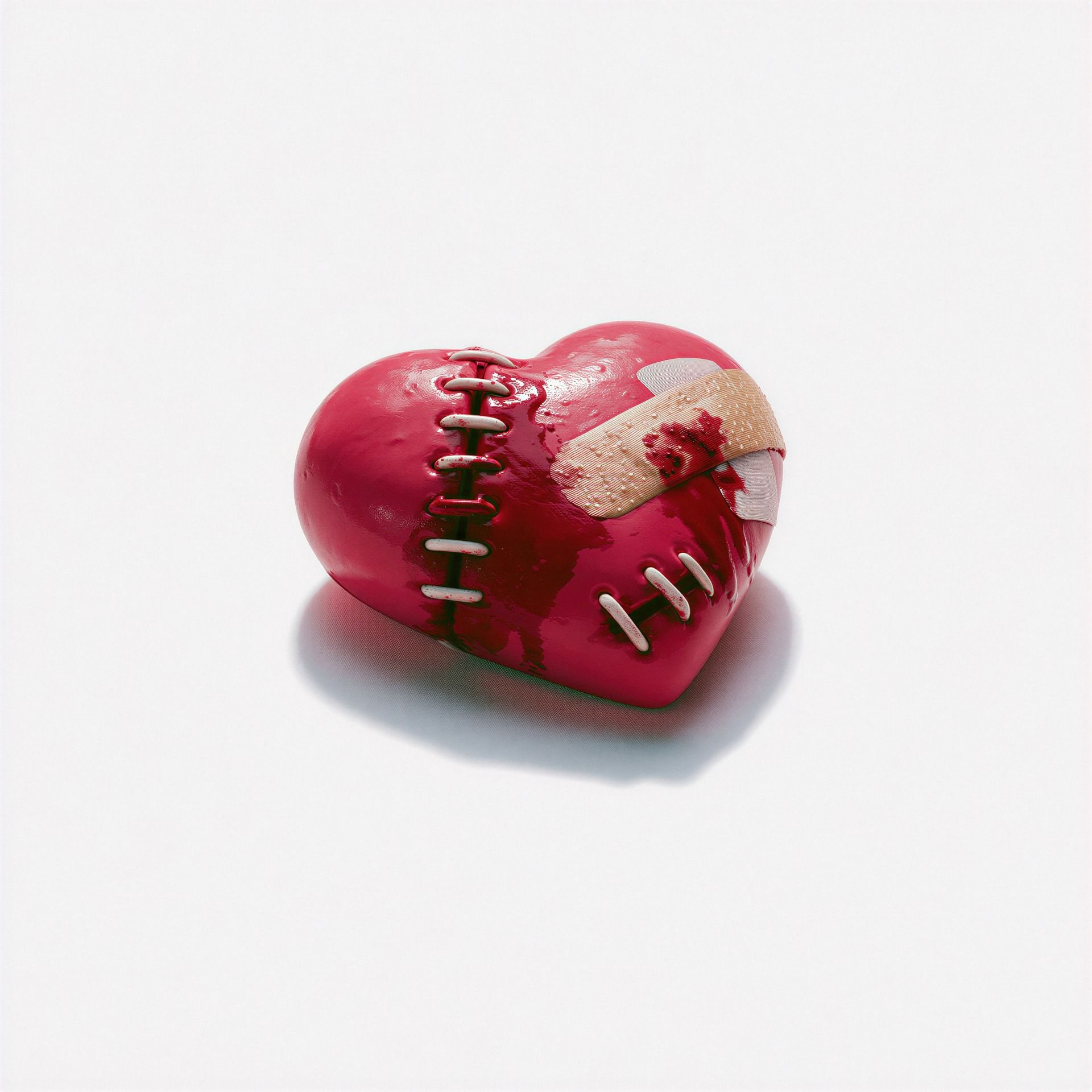 Red stitched heart with bandages on a white background