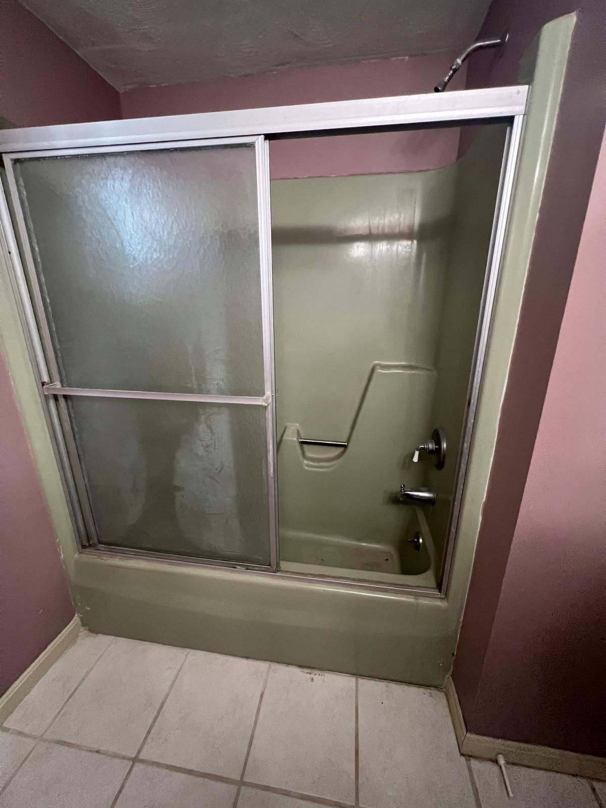a green bathtub with a sliding glass door - before services with American Bath Wroks
