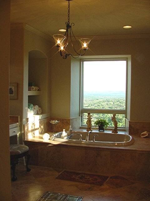 Bathroom with a large window, double sink, and bathtub overlooking a scenic view