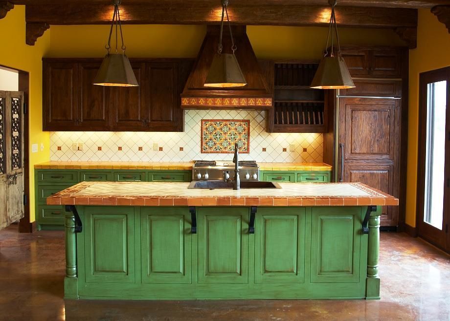 Rustic kitchen with green island, dark wood cabinets, and hanging pendant lights