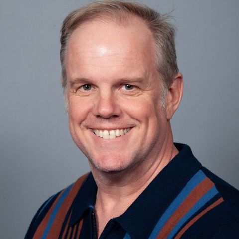 A man in a striped shirt is smiling for the camera.