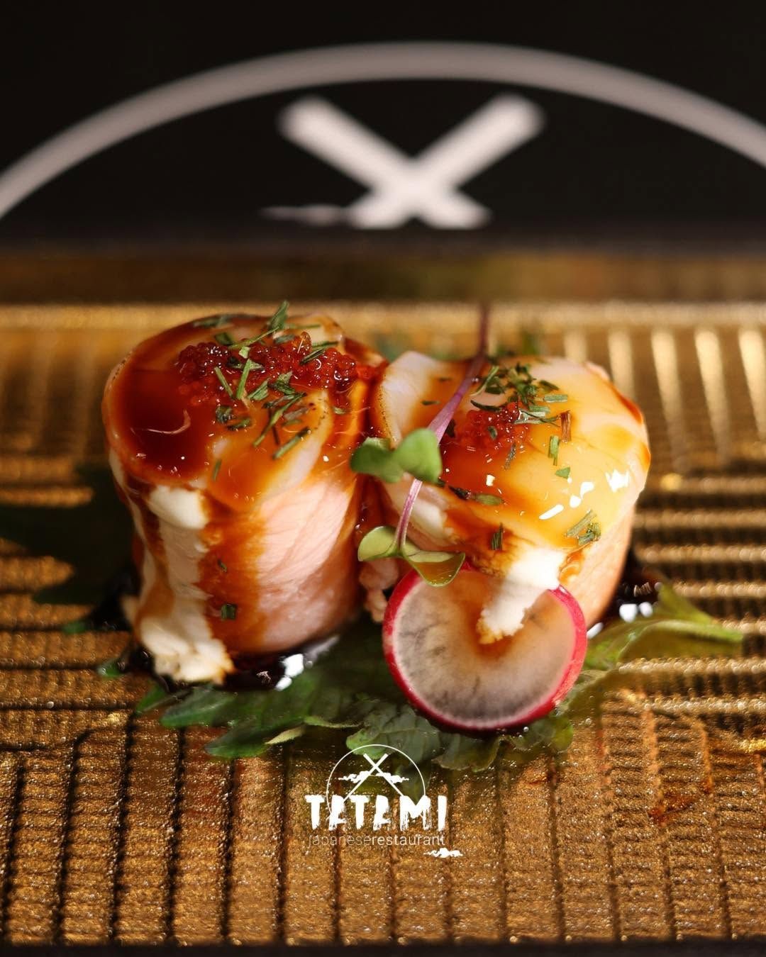 Rotolini di sushi conditi con salsa e erbe aromatiche su una stuoia intrecciata